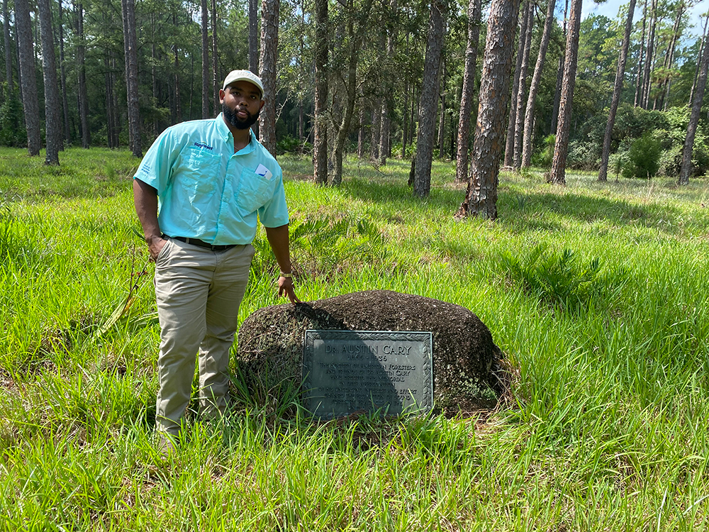 Forestry Student standing next to memorial of forestry pioneer Austin Cary