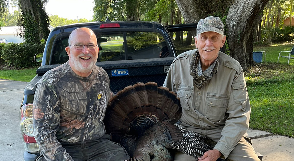 Men sitting on truck bed after hunting