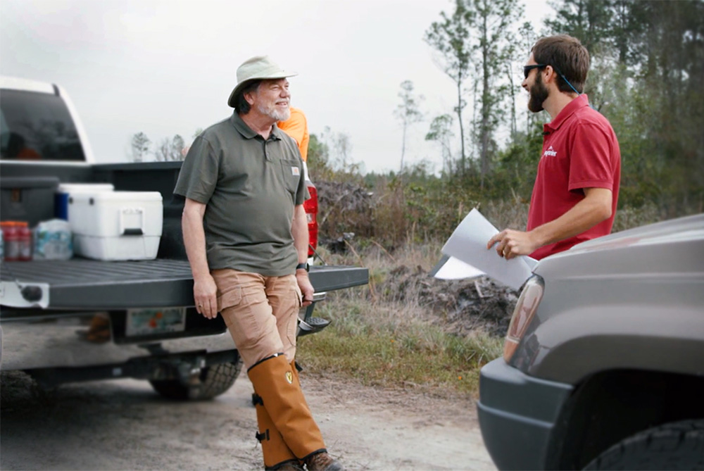 SFI auditor Richard Boitnott leaning on a truck and talking to Rayonier Forester