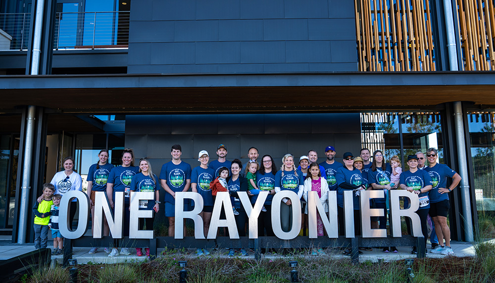Large group of people in matching tshirts standing in front of Rayonier office