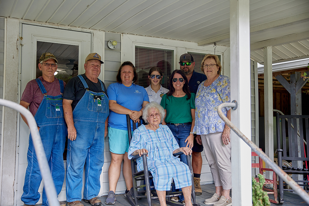 Forestry family posing together on porch of family property