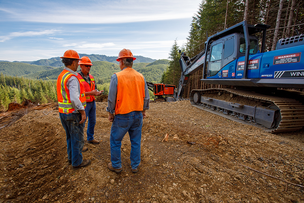 3 men working at a logging operation and discussing the strategy